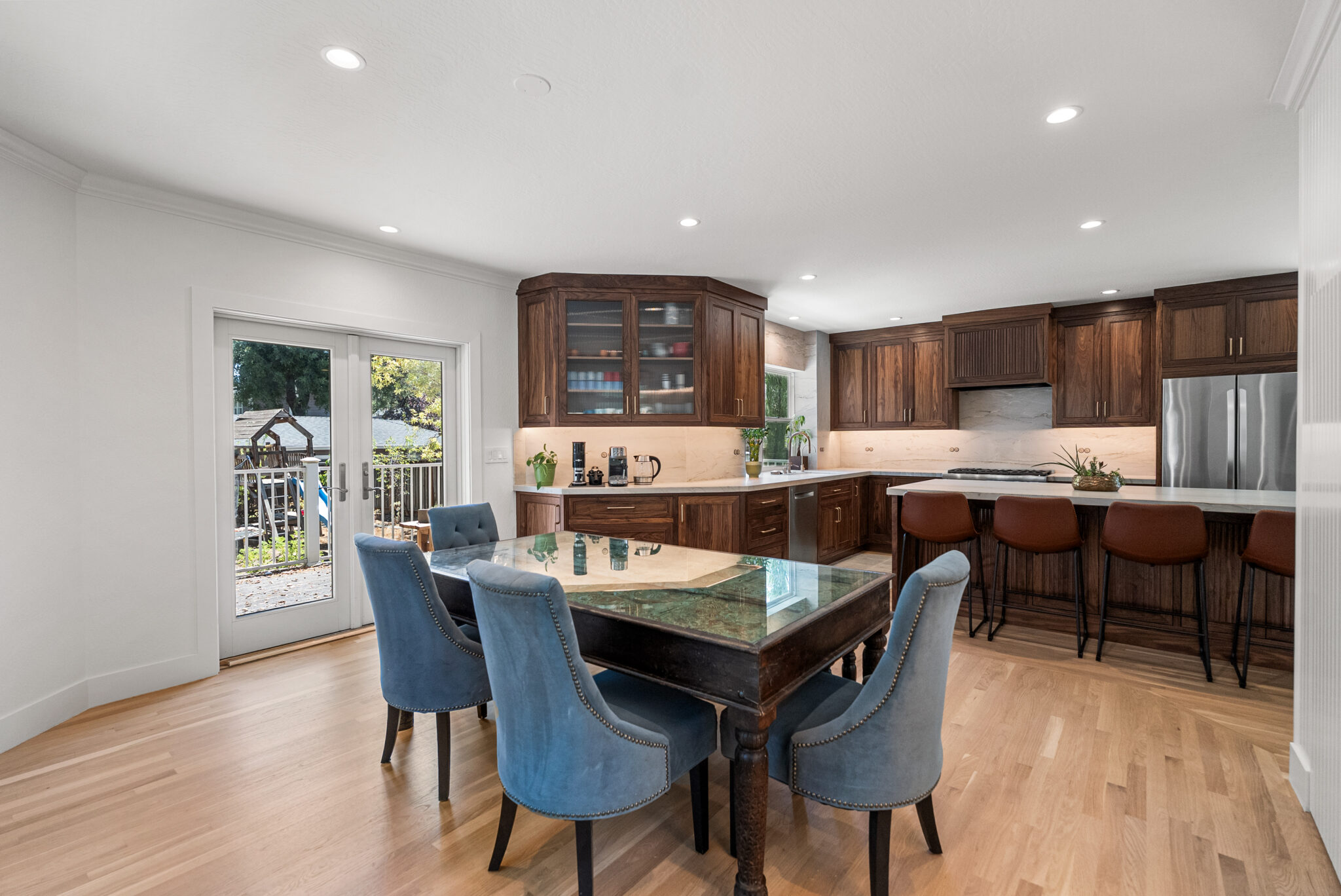 Modern kitchen with dark wood cabinets, light countertops, and dining area.
